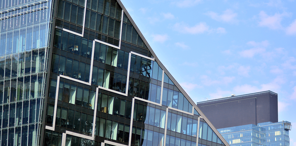 Angled glass building with abstract design on its facade